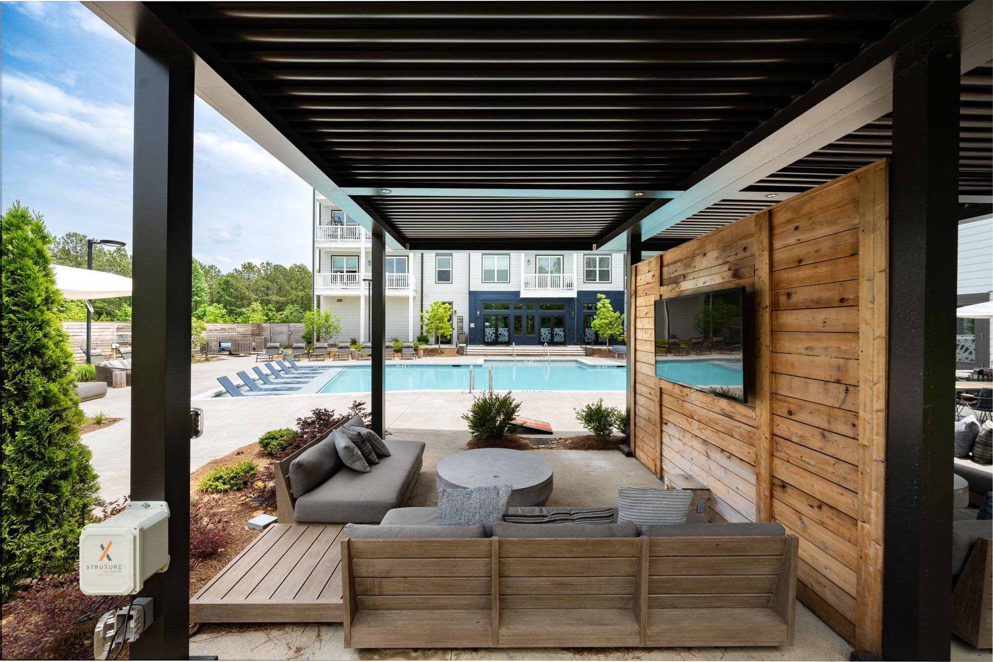 a poolside living area with a couch and a tv